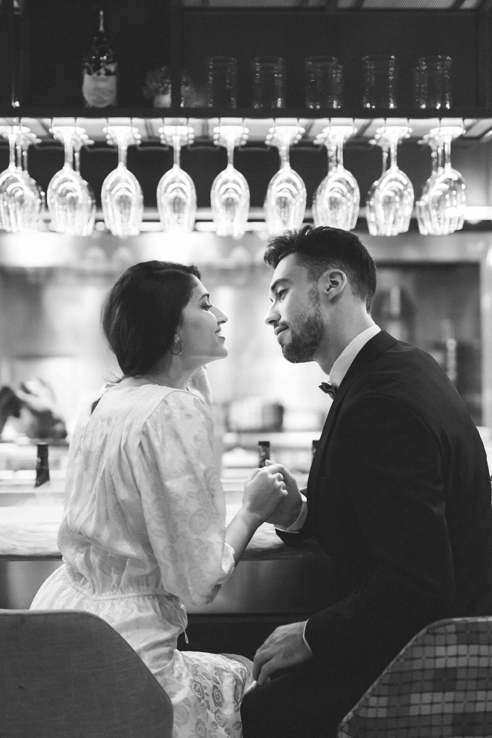 Young man holding hands with woman sitting bar counter with weddingplanner